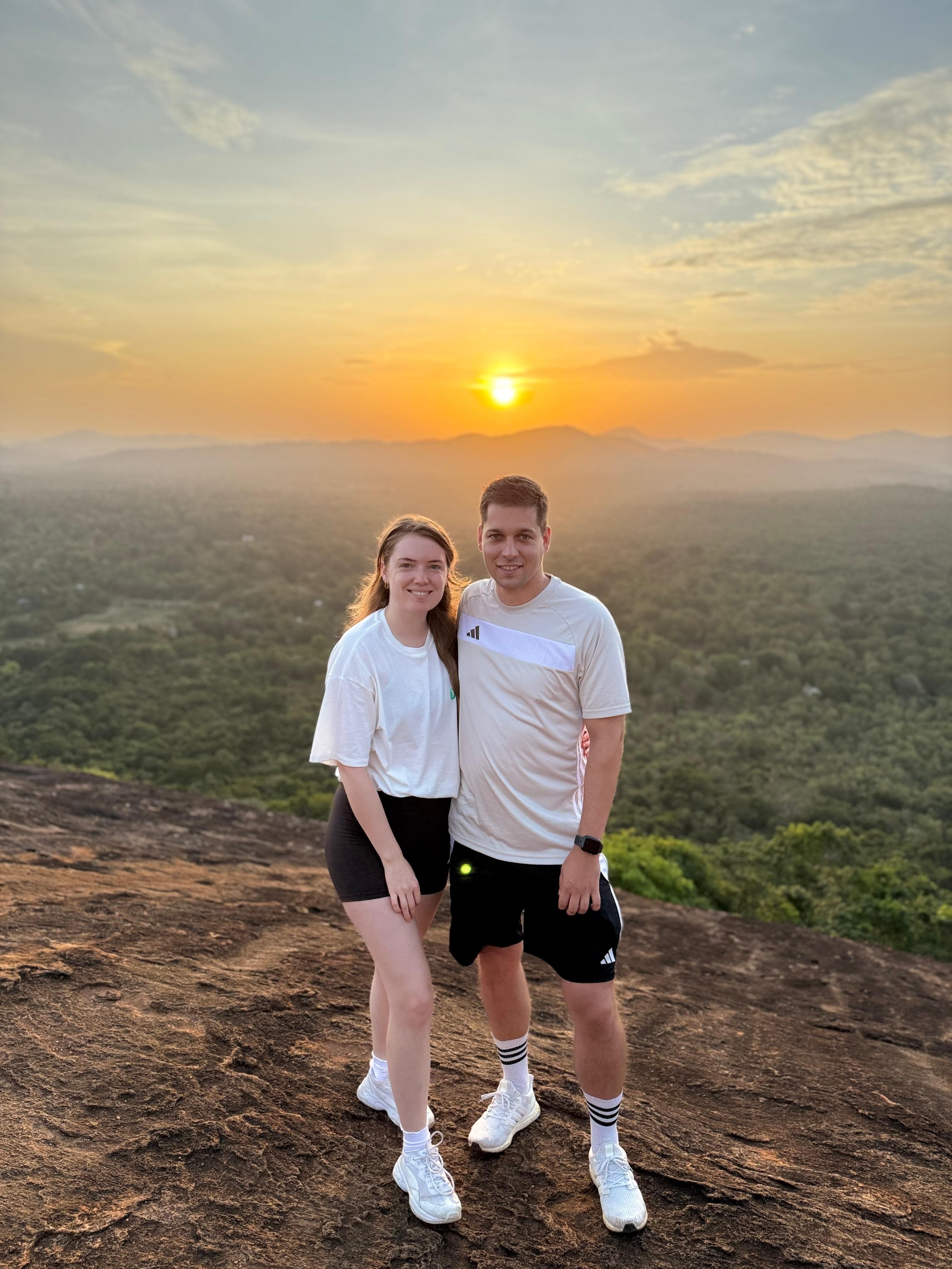 Couple watching the sunset from a hilltop