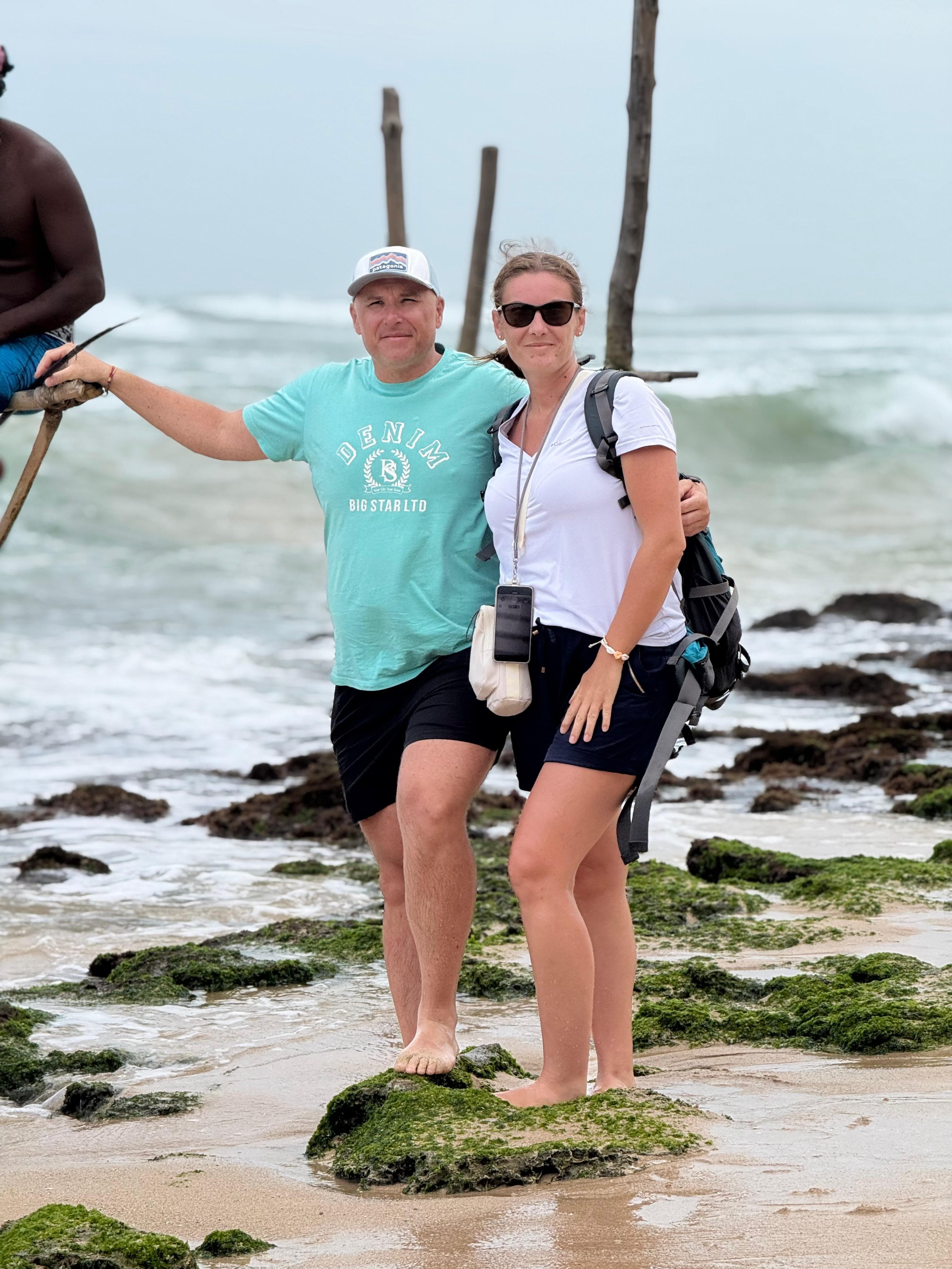 Couple on the beach beside a stilt fisherman