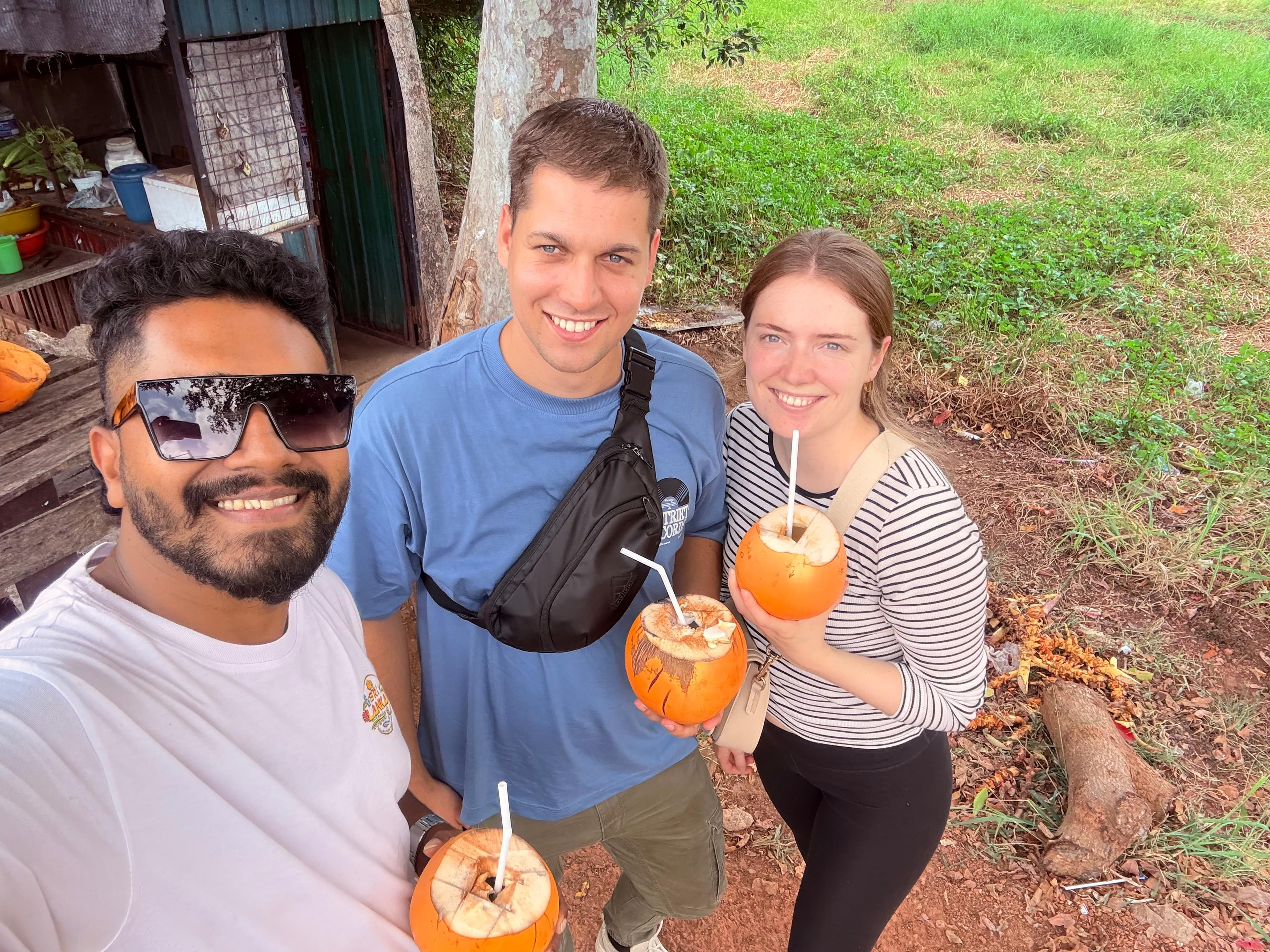 Friends and guide sharing a king coconut