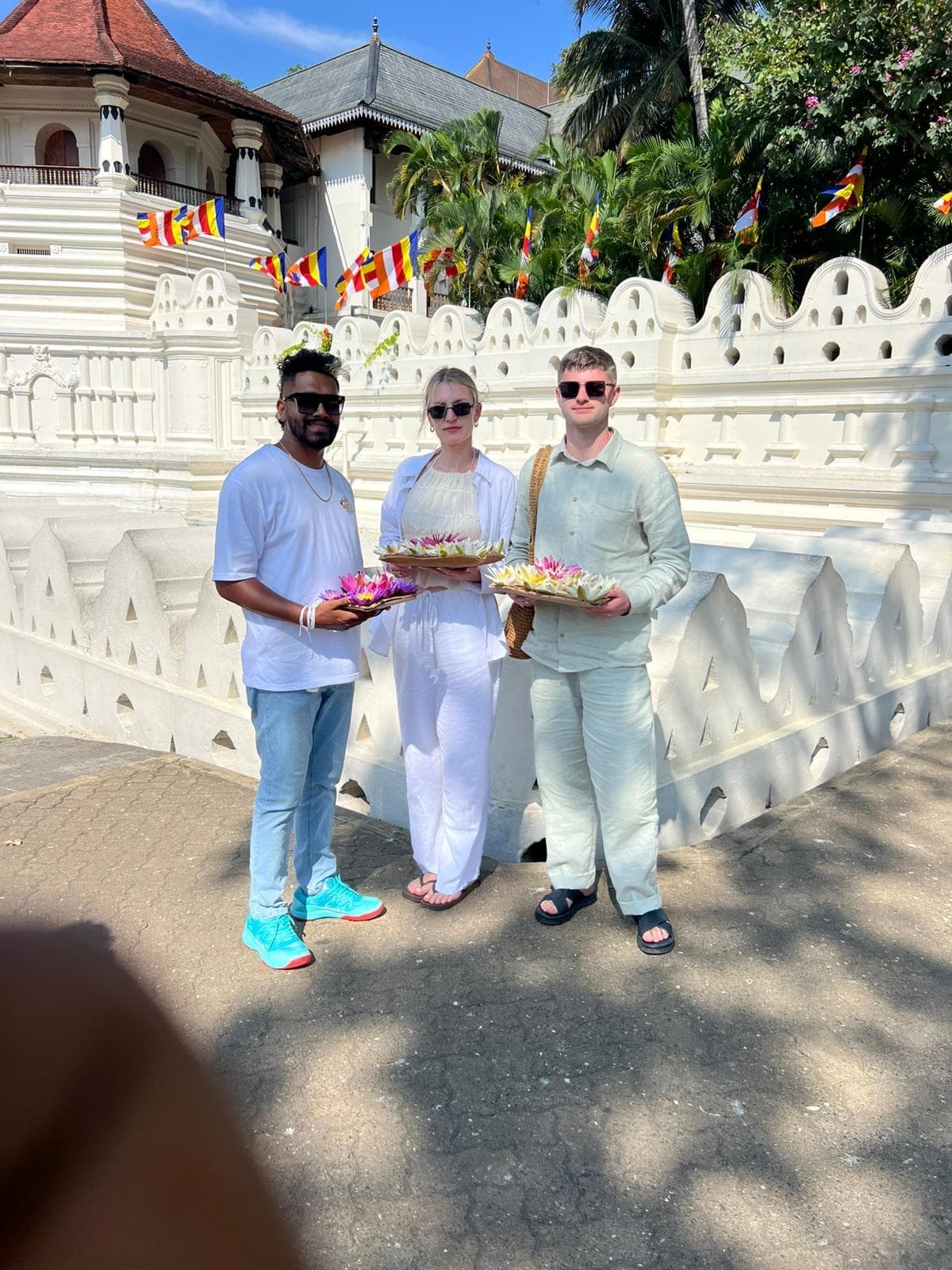 Friends making a flower offering at a Kandy temple