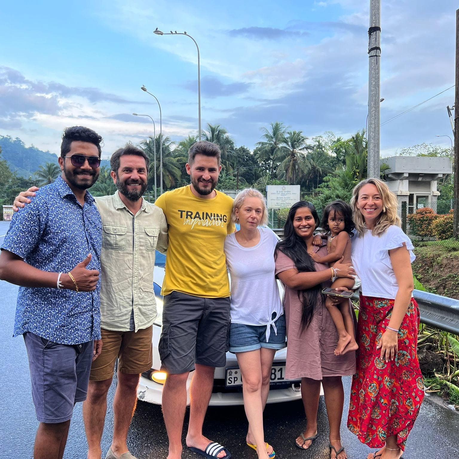 Friends group photo beside the car on the roadside