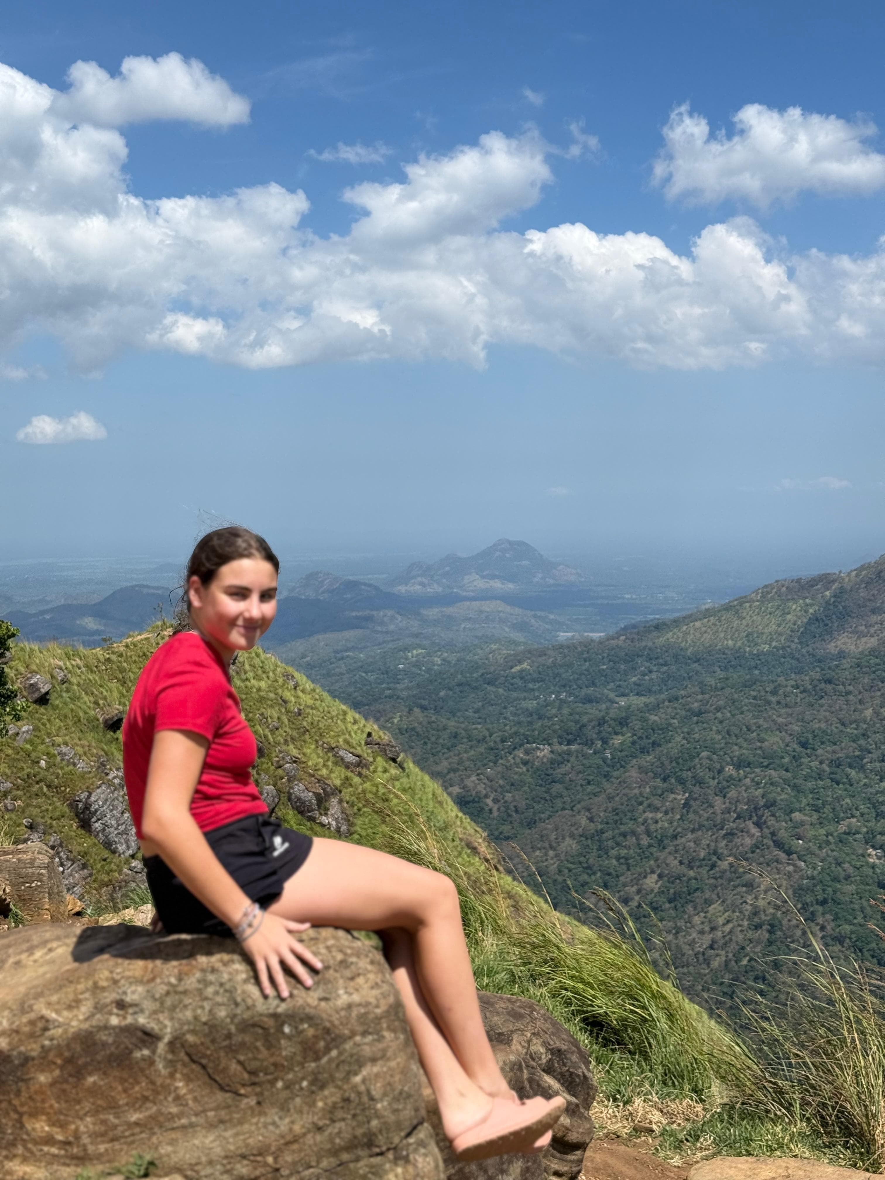 Woman on a rock at a mountain ridge viewpoint