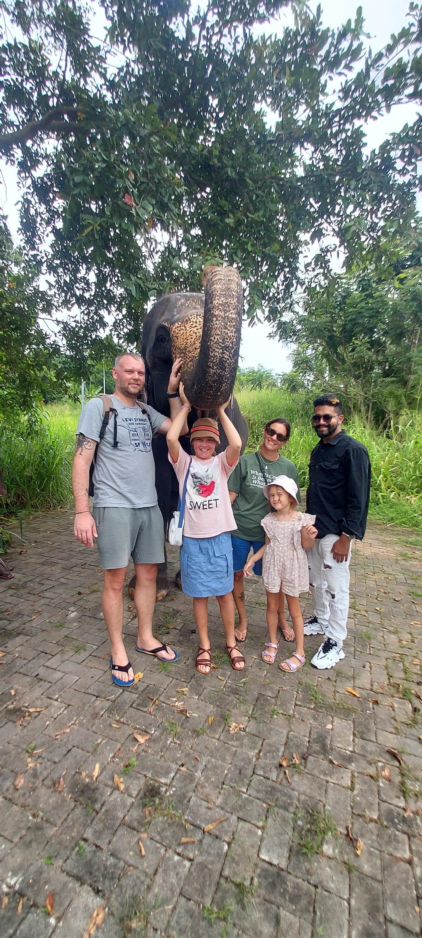 Family with an elephant under a tree
