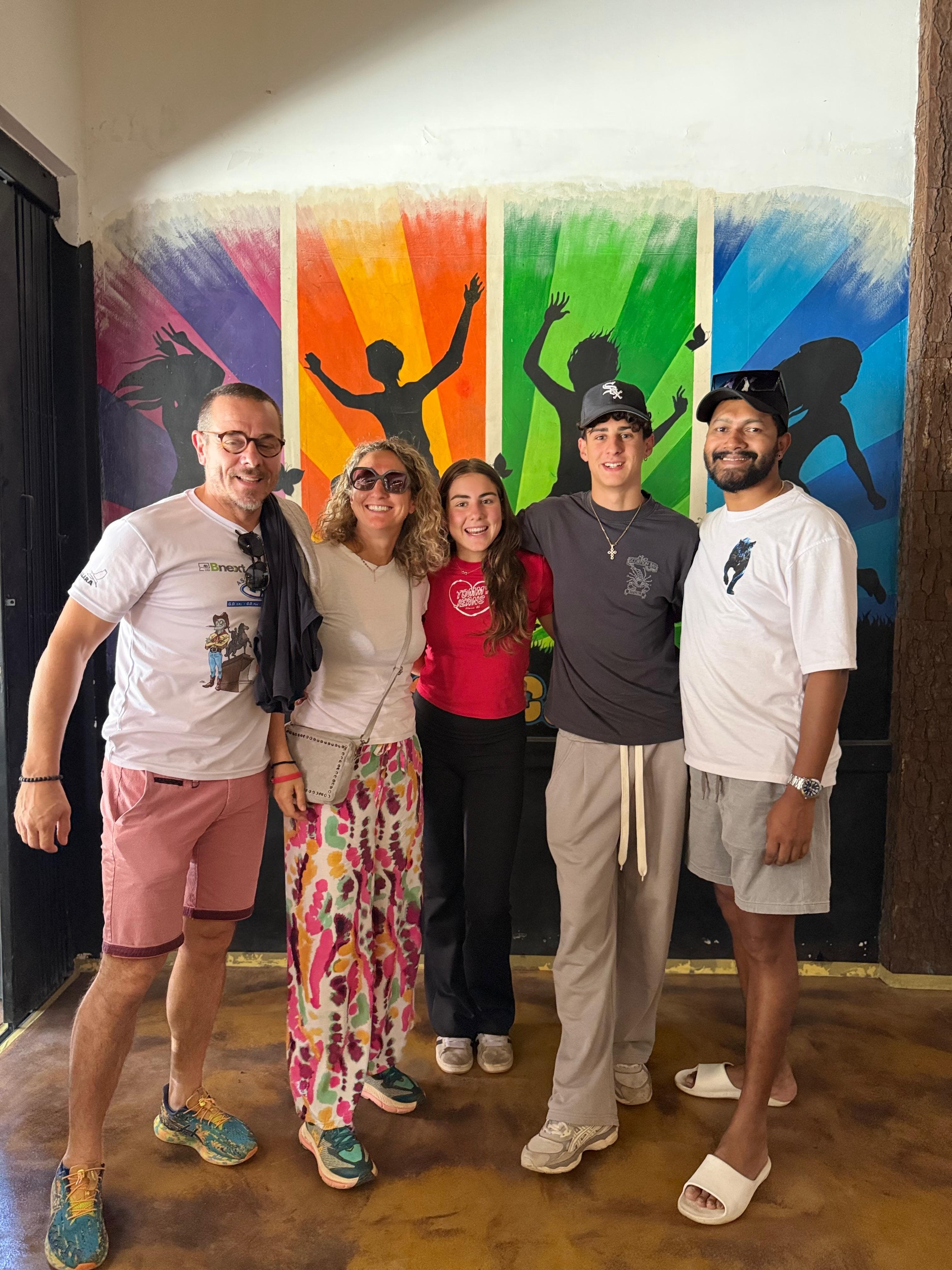 Family group beside a colorful mural wall