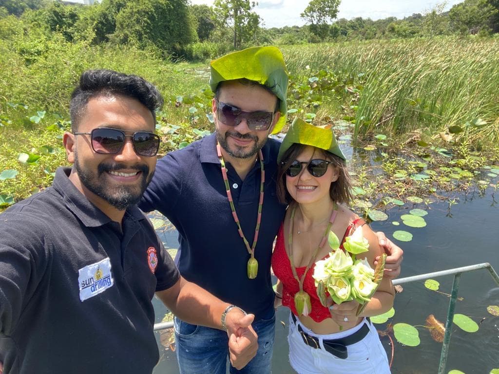 Friends wearing lotus leaf hats on a boat