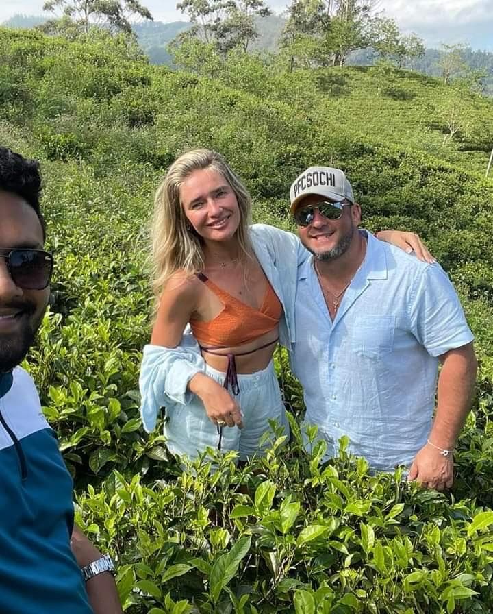 Guide and couple taking a tea plantation selfie