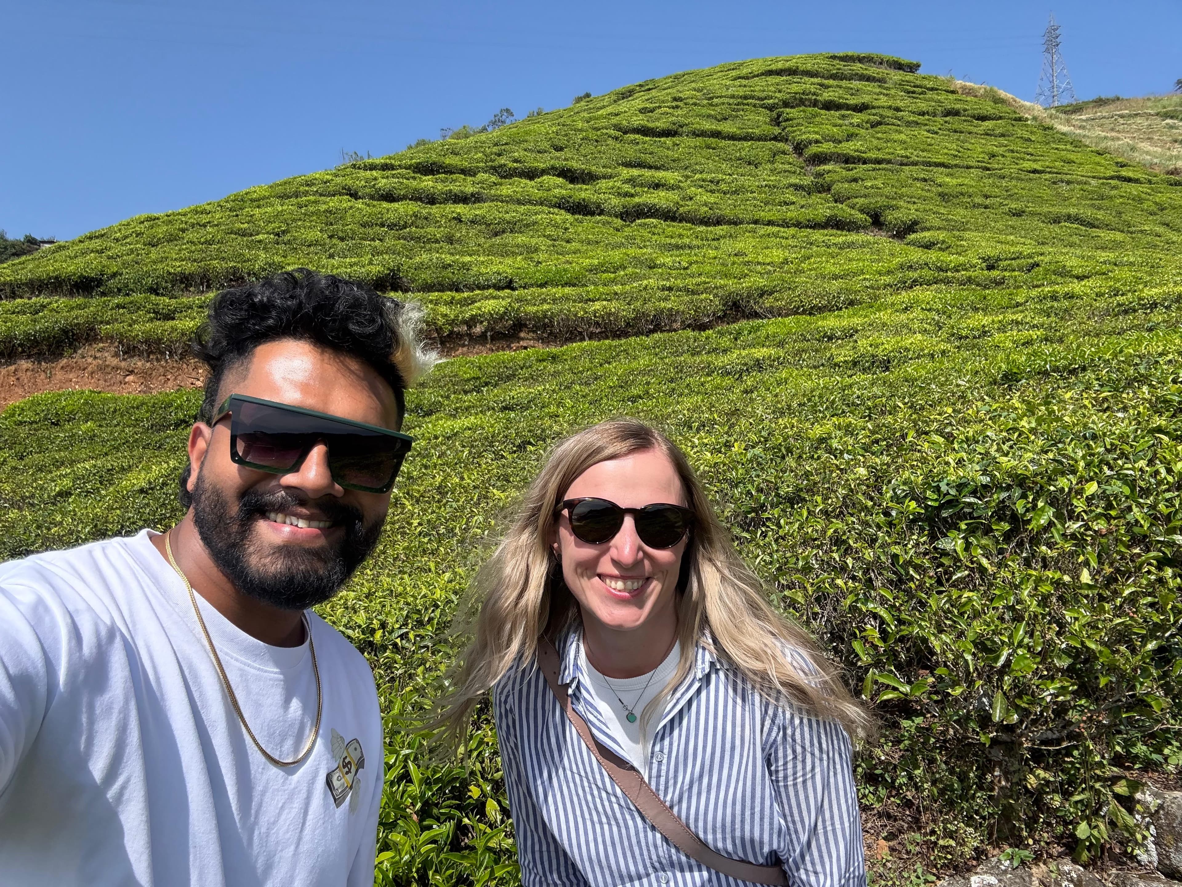 Guide and couple taking a selfie on the tea plantation hillside