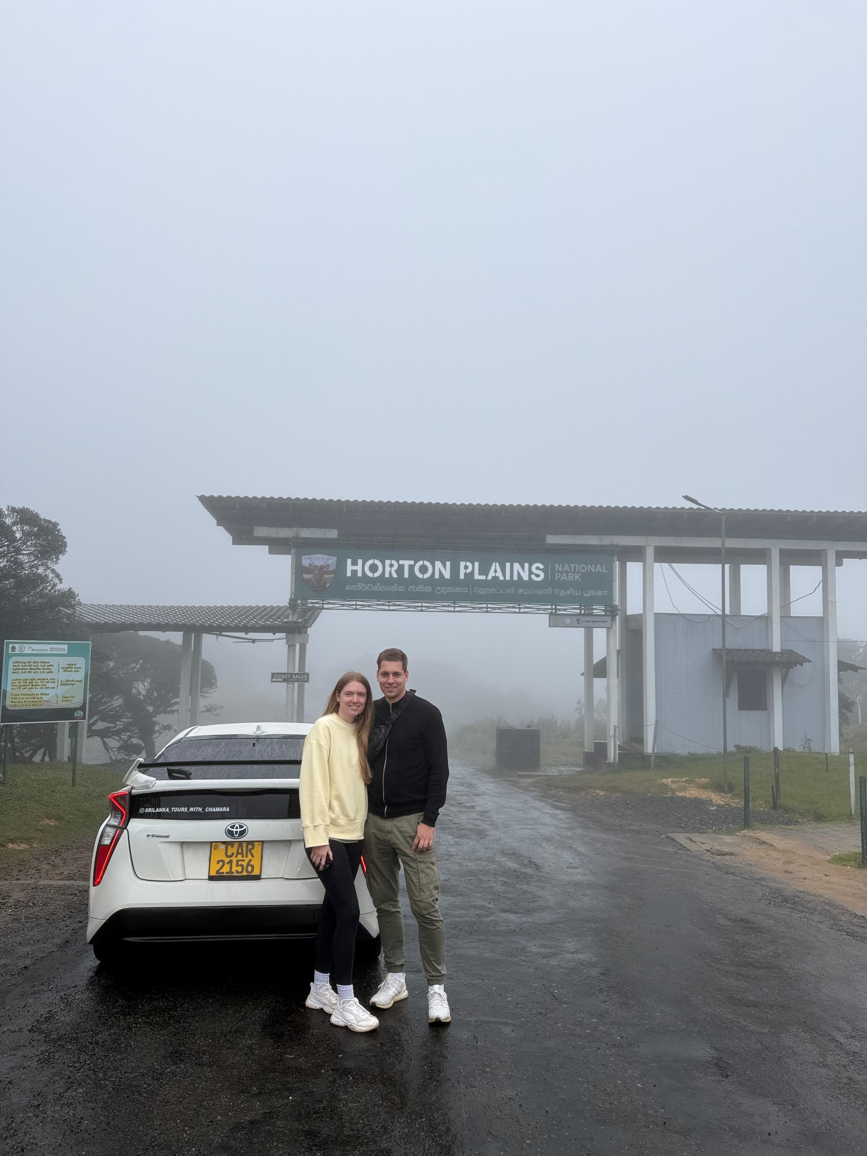 Couple at the foggy Horton Plains entrance sign