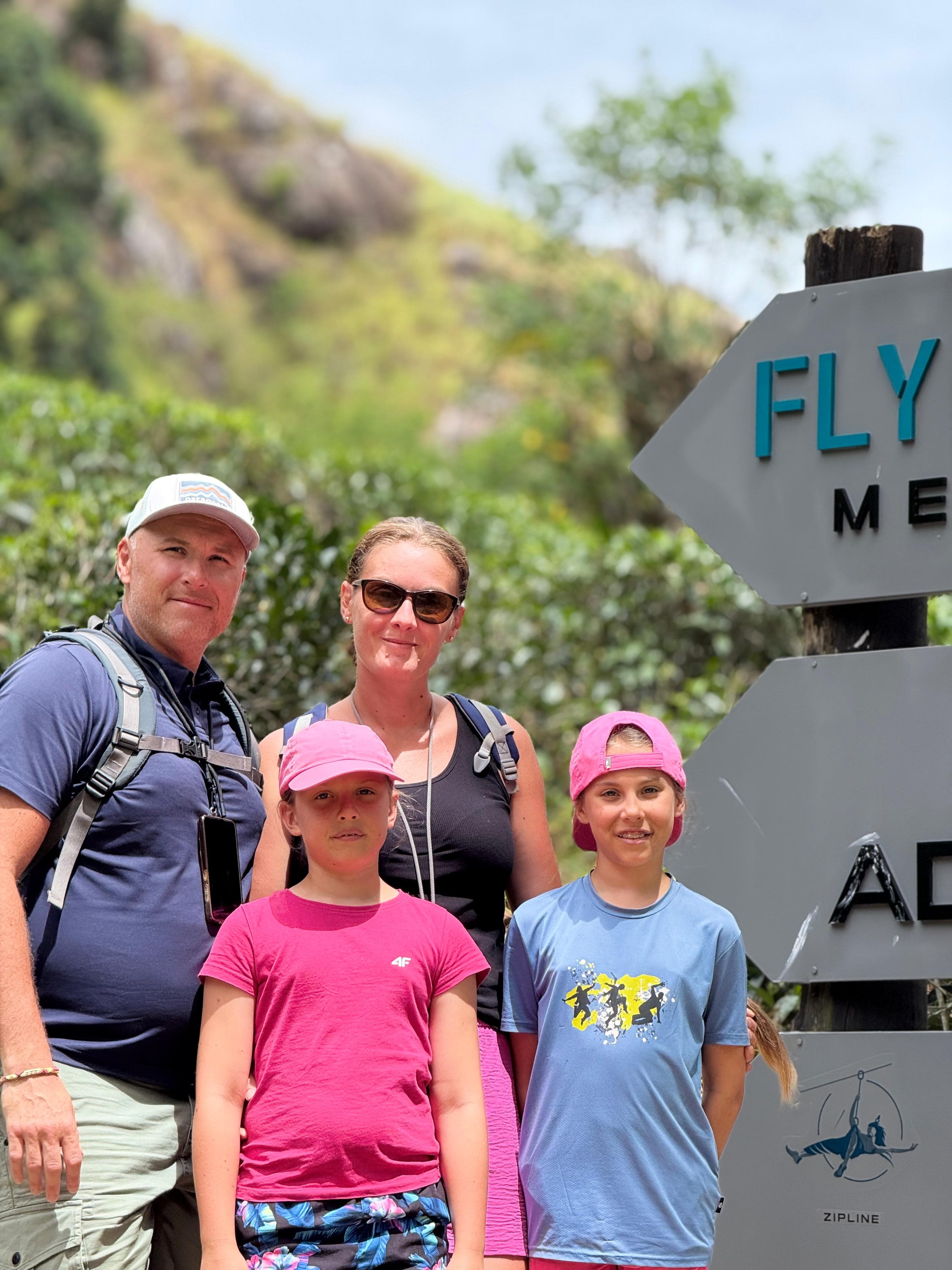 Family at the zipline adventure park sign