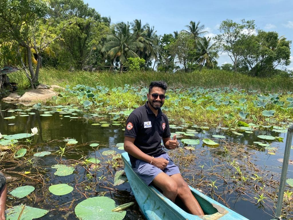 Guide giving a thumbs up from a canoe in the lotus lagoon