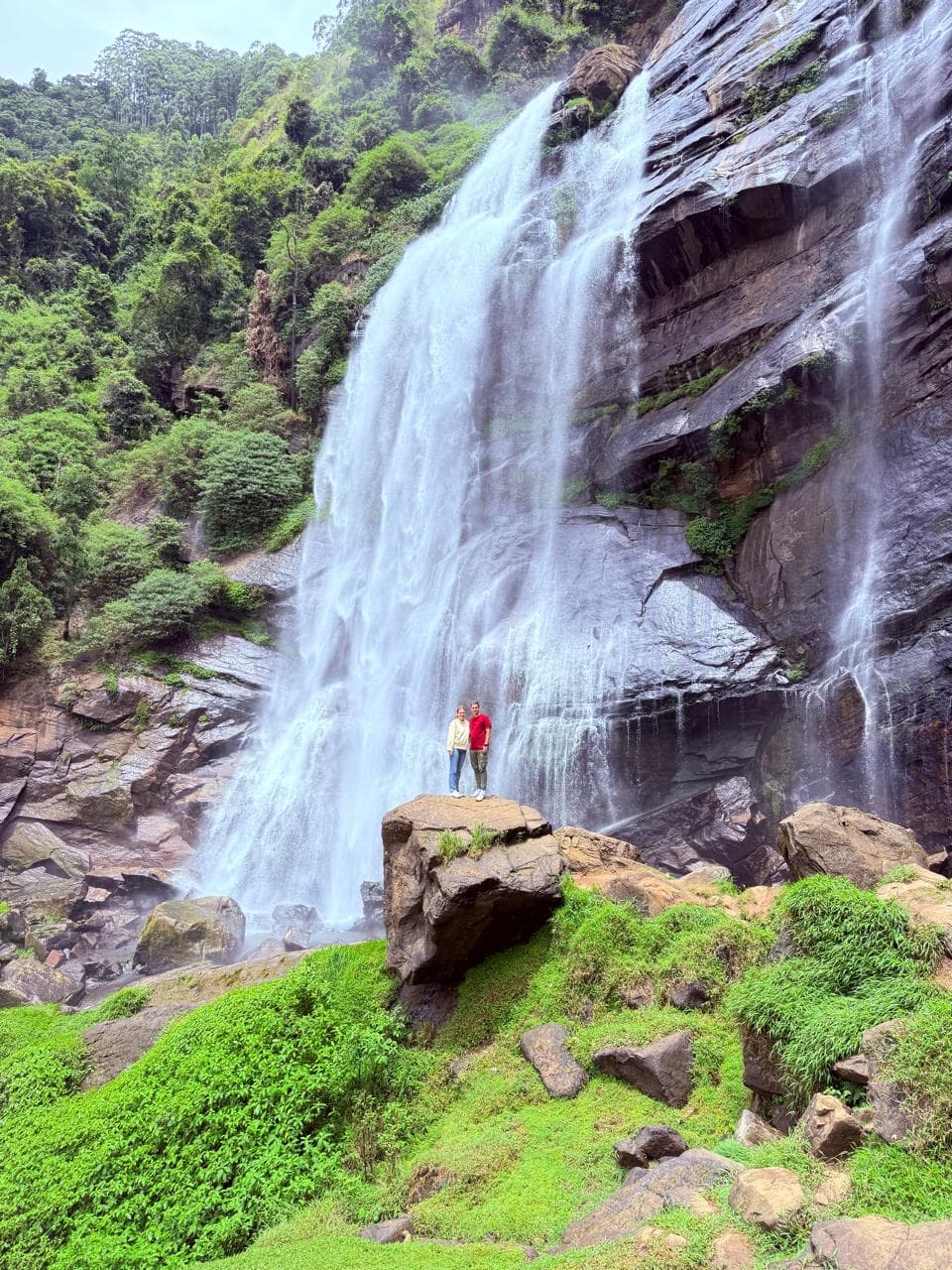 Couple portrait on a rock before a large waterfall