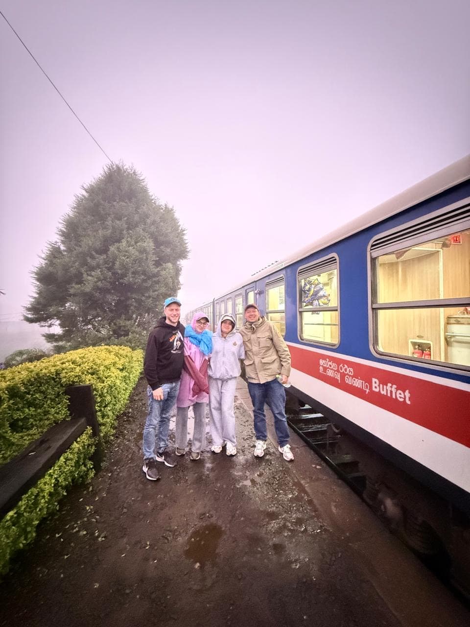 Family group portrait beside the blue train