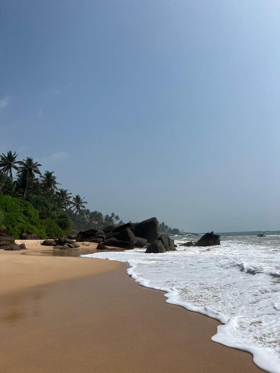 Golden sand beach along a rocky shoreline