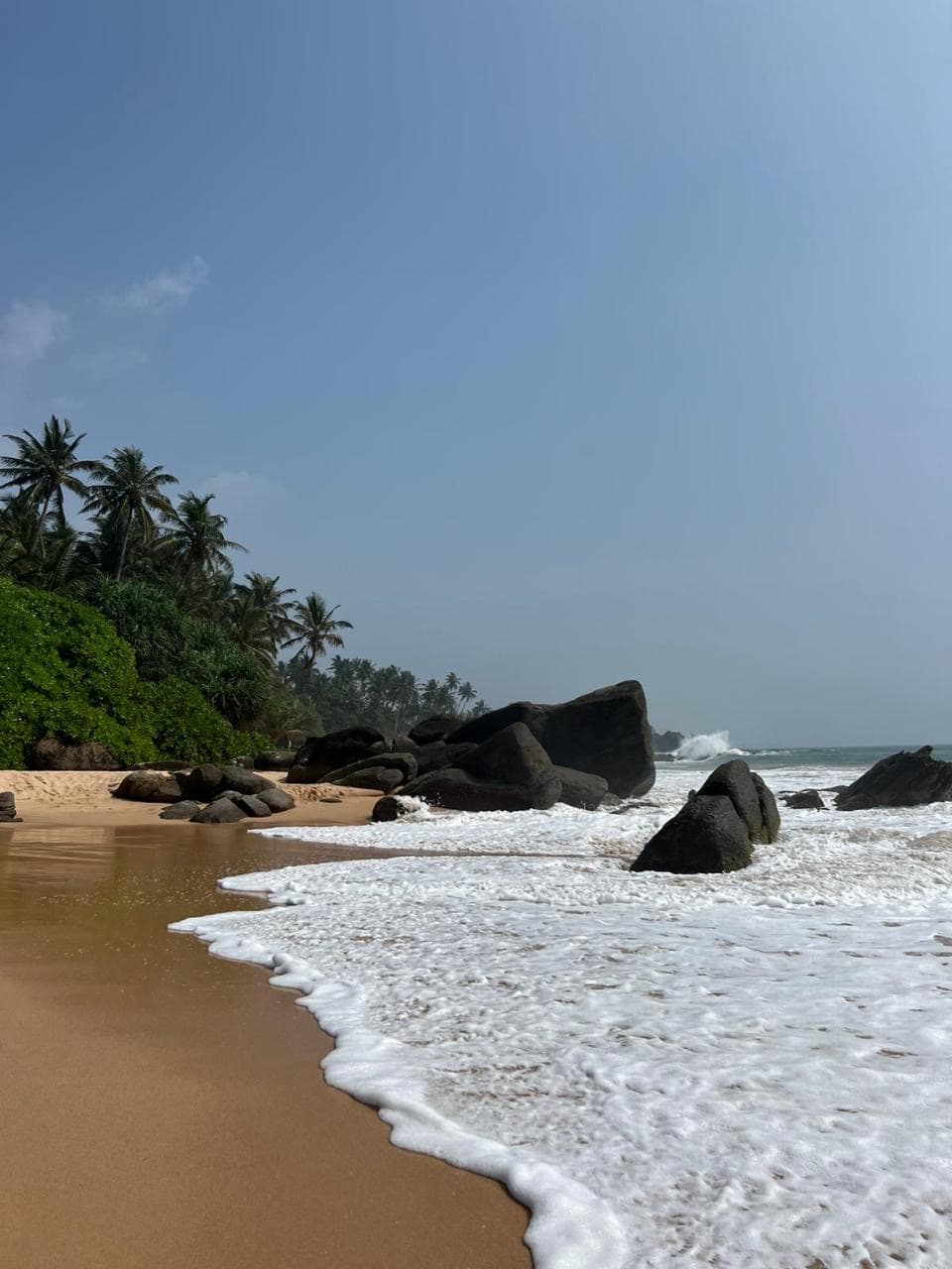 Golden sand beach along a rocky shoreline