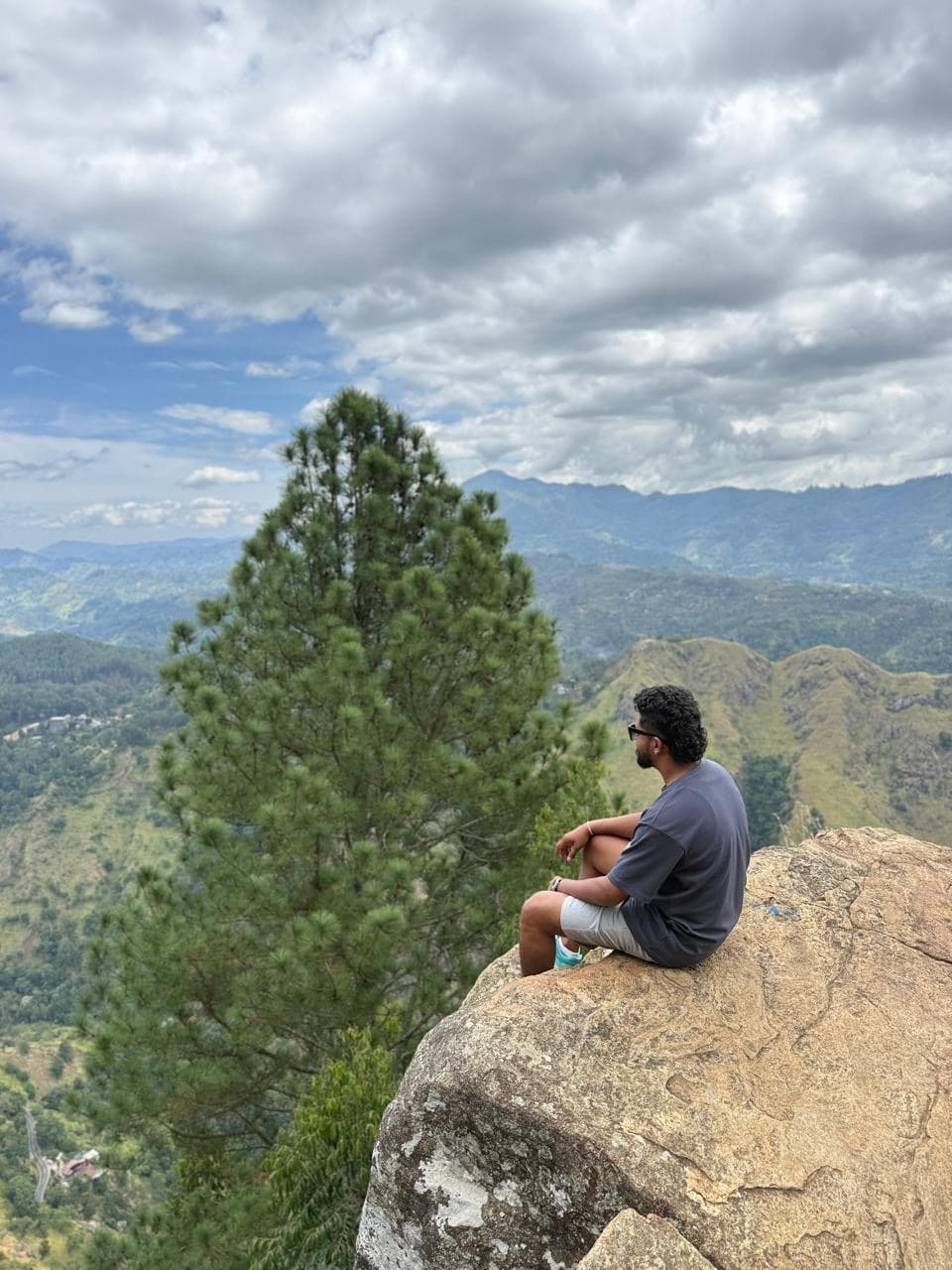 Man on a rock ledge at a mountain viewpoint