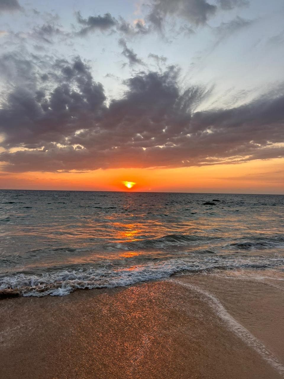 Orange sunset clouds over the beach