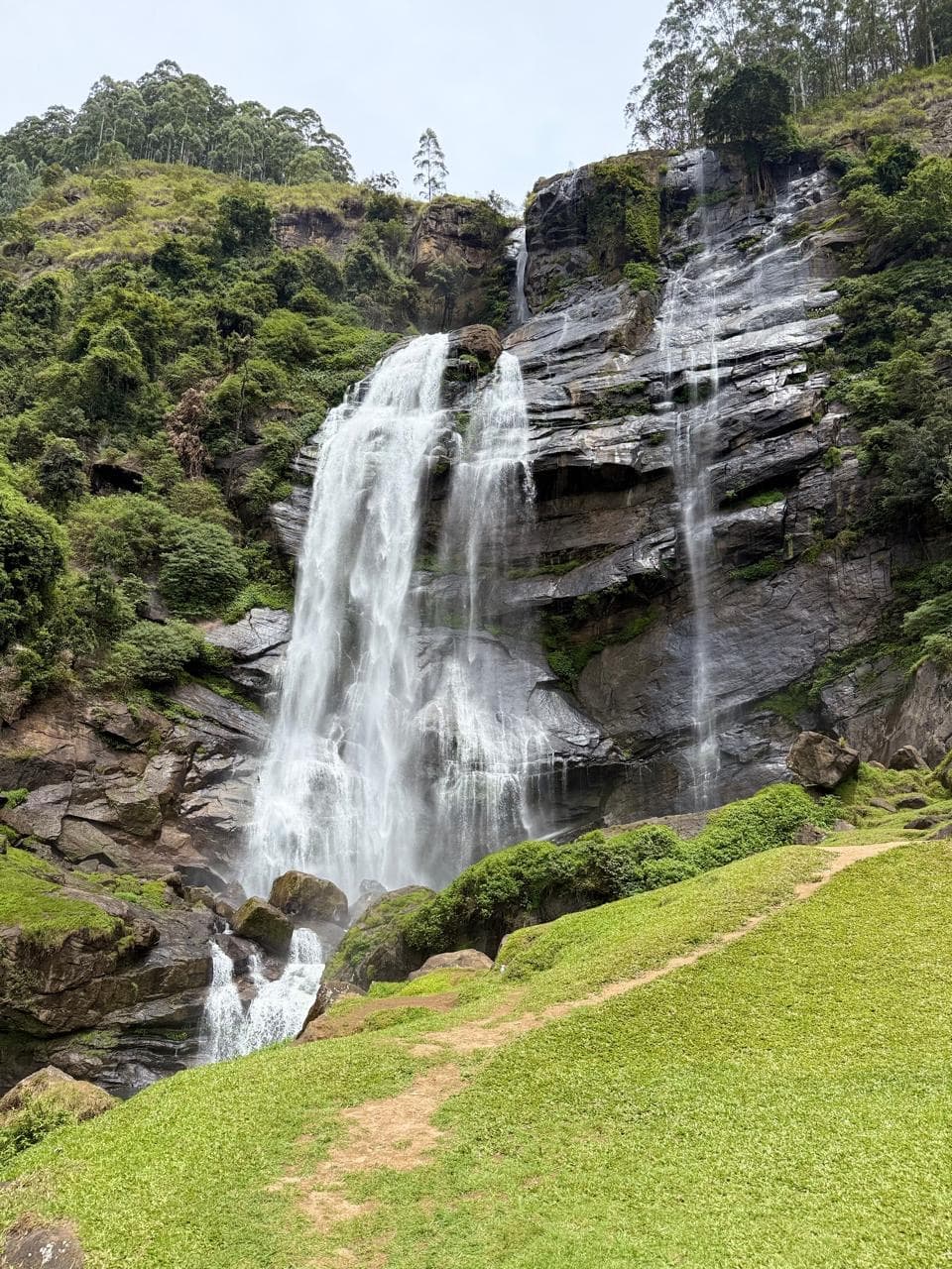 Grassy path approach to a waterfall