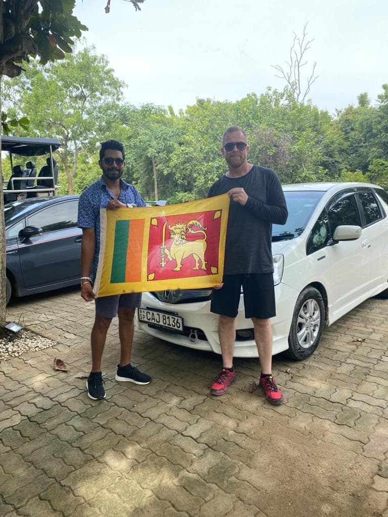 With the Sri Lanka flag beside the tour vehicles